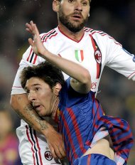 Barcelona's Argentinian forward Lionel Messi (front) fights for the ball with AC Milan's defender Antonio Nocerino during the Champions League quarter-final second leg football match FC Barcelona vs AC Milan at Camp Nou stadium in Barcelona. Barca won 3-1 to reach semi-finals. (AFP Photo/Lluis Gene)