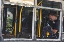 An Israeli police officer takes pictures inside a damaged bus at the scene of an explosion in Bat Yam