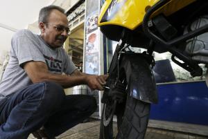 Mechanic Giorgos Prasinoudis fixes the brakes of a …