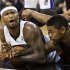 Sacramento Kings' DeMarcus Cousins and Toronto Raptors' Amir Johnson tangle over the ball during the second half of their NBA basketball game in Sacramento