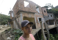 Vanessa Silva habla frente a su casa dañada por un alud de lodo causado por las lluvias torrenciales de enero, en Teresopolis, Brasil, el martes 26 de julio de 2011. Las lluvias torrenciales de enero provocaron deslizamientos en las laderas de las montañas de Río de Janeiro y mataron a 981 personas. No se tiene noticias de otras 322, que probablemente hayan fallecido. Unas 32.000 se quedaron sin vivienda. (Foto AP/Silvia Izquierdo)