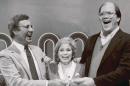 File-This Jan. 16, 1986. file photo shows host Jim Lange, left, congratulating Connie and Steve Rutenbar of Mission Viejo, Calif., after they won $1 million on the TV show " The $1,000,000 Chance of a Lifetime". Lange, the first host of the popular game show "The Dating Game," has died at his home in Mill Valley, Calif. He was 81. He died Tuesday morning after suffering a heart attack, his wife Nancy told The Associated Press Wednesday, Feb. 26, 2014. (AP Photo/File)