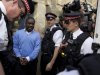 FILE - In this Sept. 16, 2011 file photo, former UBS trader Kweku Adoboli, second from left, walks to be taken away in a security van flanked by police officers after appearing at the City of London Magistrates Court in London. Britain's financial regulator said Monday, Nov. 26, 2012 that it has fined Swiss bank UBS AG for failings which allowed rogue trader Kweku Adoboli to lose $2.3 billion. (AP Photo/Matt Dunham, File)