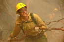 FILE - In this July 30, 2008 file photo, Rio Bravo Hotshot firefighter Cole Cates clears manzanita while cutting a fireline on the Telegraph Fire near Yosemite National Park in California. In American culture, the firefighter is almost a mythic being and it is no different in the wildland firefighting community, where men and women armed with little more than axes, shovels and chain saws face mountainsides engulfed in flames. (AP Photo/Ron Lewis, File)