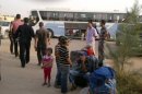 Syrians are seen at the Abu Kamal Iraqi-Syrian border crossing as some 400 refugees fleeing the fighting arrive in Iraq