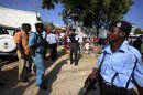 Somali policemen mill around the scene of a suicide attack in capital Mogadishu