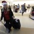 FILE - In this Dec. 21, 2010 file photo, holiday travelers collect their luggage at the San Jose International Airport in San Jose, Calif. Flying over the holidays is going to cost more this year. And the longer you wait to book, the pricier it’s likely to get. (AP Photo/Marcio Jose Sanchez, File)