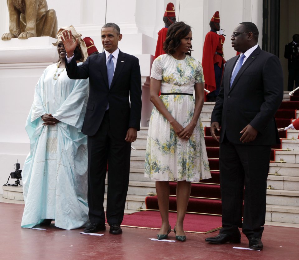 U.S. President Barack Obama waves as he poses for a picture alongside U.S. First Lady Michelle Obama, second right, Senegalese President Macky Sall, right, and Senegalese First Lady Mariame Faye Sall at the presidential palace in Dakar, Senegal, Thursday, June 27, 2013. President Obama arrived in Senegal Wednesday night to kick off a weeklong trip to Africa, a three-country visit aimed at overcoming disappointment on the continent over the first black U.S. president's lack of personal engagement during his first term. (AP Photo/Rebecca Blackwell)