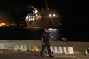 A Cypriot policeman walks on the dock as the Salamis Filoxenia cruise liner, carrying 345 people thought to be Syrian refugees and rescued off the coast, prepares to dock at the port in Limassol on September 25, 2014