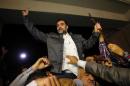 One of the nine Lebanese Shiite pilgrims abducted by rebels in Syria flashes the V-sign for victory ashe is greeted by relatives upon his arrival at Beirut International airport on October 19, 2013