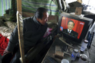 <p>               A vendor watches the live telecast of the annual government work report by outgoing Premier Wen Jiabao on a television in a vegetable wholesale market in Fuyang in central China's Anhui province Tuesday, March 5, 2013. China's government promised its people Tuesday deficit-fueled spending to fight deep-seated corruption, improve the despoiled environment and address other quality-of-life issues demanded by an increasingly vocal public looking for change.  (AP Photo) CHINA OUT