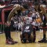 Miami Heat's Udonis Haslem, left, and Mario Chalmers, right, check on teammate LeBron James (6) after he took a fall during the second half of an NBA basketball game against the Phoenix Suns in Miami, Tuesday, March 20, 2012. The Heat defeated the Suns 99-95. (AP Photo/J Pat Carter)