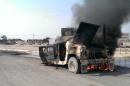 Smoke rises from an Iraqi army vehicle following an attack by armed militants in the Anbar city of Fallujah, on January 26, 2014