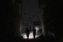Free Syrian Army fighters move along a street at night in Aleppo's Karm al-Jabal district