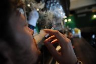Romeno fuma cigarro em um bar de Bucareste, em 21 de junho de 2011