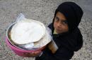 A Kurdish refugee boy from the Syrian town of Kobani carries food for his family during lunch time at a refugee camp in the border town of Suruc