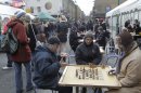 In this Sunday, Jan. 29, 2012 photo, people play a game of chess on Brick Lane in east London. It's no wonder that for a long time, east London has been all but ignored by tourists who stick to the West End, the home of blockbuster musicals, royal palaces, Harrods and Oxford Street. This year, those prejudices are likely to change as the Olympics inject huge investments into changing the face of the East End. (AP Photo/Sang Tan)