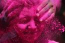 An Indian woman shuts her eyes as colored powder is smeared on her face during celebrations marking Holi, the Hindu festival of colors, in Mumbai, India, Friday, March 6, 2015. Holi, India's joyful and colorful celebration of the arrival of spring along with several religious myths and legends, has long ceased to be only a Hindu festival. The streets and lanes across most of India turn into a large playground where people of all faiths throw colored powder and water at each other. (AP Photo/Rajanish Kakade)