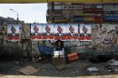 An Egyptian girl street vendor displays dairy products for sale under electoral posters with pictures of presidential hopeful Abdel-Moneim Abolfotoh and Arabic that reads, 