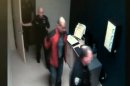 In this image taken from video at the Sanford, Fla., Police Department, George Zimmerman, in red jacket, is escorted into the Sanford police station in handcuffs on Feb. 26, 2012, the night he fatally shot Trayvon Martin. (AP Photo/Sanford Police Department)