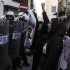 Bahraini anti-government activist Zainab al-Khawaja, second right, gestures and chants slogans in front of riot police during a protest Wednesday, April 18, 2012, in downtown Manama, Bahrain. Security forces fired stun grenades at the protesters who swarmed into a cultural exhibition for the Formula Bahrain One Grand Prix race, setting off street battles and sending visitors fleeing for cover. (AP Photo/Hasan Jamali)