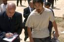 FILE - In this April 17, 2004 file photo, Japanese freelance journalist Jumpei Yasuda, right, is escorted after being released at Umm Al-Qura mosque in Baghdad, Iraq. Worries are growing about the whereabouts of the freelance Japanese journalist, last heard from late June, 2015, in Syria. It is not known why Yasuda, who has been reporting on the Middle East since 2002, has not been in contact or if he has been taken captive in the war-torn nation. (AP Photo/Muhammed Muheisen, File)