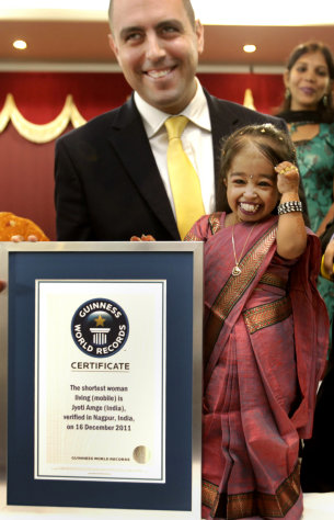 Jyoti Amge smiles after getting the title of the shortest woman by the Guinness World Records adjudicator Rob Molloy, in Nagpur, India, Friday, Dec. 16, 2011. Amge was declared the shortest woman in the world measuring 62.8 centimeters (24.7 inches) by the Guinness World Records. (AP Photo/ Manish Swarup)