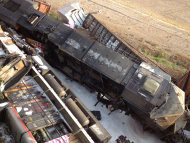 Damaged railcars lie on the ground near Rockview, Mo. on Saturday, May 25, 2013. Authorities said a highway overpass collapsed when rail cars slammed into one of the bridge's pillars after a cargo train collision. Seven people were injured, though none seriously. (AP Photo/KFVS, Michael Mohundro)