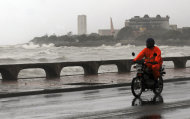 A motorcyclist rides along the Santo Domingo waterfront as Tropical Storm Emily approaches the shores of the Dominican Republic, Wednesday Aug. 3, 2010. Forecasters say Emily will drop a huge amount of rain on the Dominican Republic and Haiti and is expected to reach the southwestern Dominican coast late Wednesday. (AP Photo/Manuel Diaz)