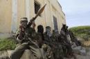 Al Shabaab soldiers sit outside a building during patrol along the streets of Dayniile district in Southern Mogadishu