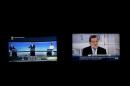 Two screens show three of the main candidates for Spain's national election at a live debate hosted by Spanish newspaper El Pais and Spanish PM Rajoy, who declined to attend that debate, at a simultaneous live interview at Telecinco TV in Madrid