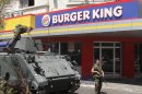 Lebanese army soldiers with their armored personnel carrier, stand guard outside a Burger King as part of stepped up security measures in the southern port city of Sidon, Lebanon, Saturday Sept. 15, 2012. Angry protesters attacked on Friday a Hardees and Kentucky Fried Chicken outlets in Tripoli north Lebanon to protest against a movie that insults Prophet Muhammad. (AP Photo/Mohammed Zaatari)