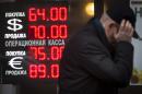 FILE - In this Tuesday, Dec. 16, 2014, file photo, a man walks by a sign advertising currencies of an exchange office in Moscow. Russia has been badly affected by the slide in oil prices in 2014, and the ruble has plunged despite big increases in interest rates as much of Russia's economy is based on energy. (AP Photo/Alexander Zemlianichenko, File )