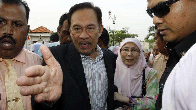 Malaysian opposition leader Anwar Ibrahim, center, and his wife Wan Azizah, second from right, arrive at a courthouse in Kuala Lumpur, Malaysia, Monday, May 16, 2011. Malaysia's High Court will decide on Monday whether to dismiss the sodomy charge against Anwar or order his lawyers to start calling defense witnesses. Anwar faces up to 20 years in prison if convicted of sodomizing a male former aide in 2008. (AP Photo/Lai Seng Sin)