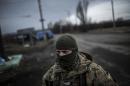 A Ukrainian soldier stands watch on a road between Debaltseve and the Ukrainian-controlled town of Artemivsk, in the Donetsk region, on February 2, 2015