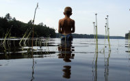 Tyler Carter, 6, of Auburn, Maine, wades in Sabbathday Lake to fish for bass, in New Gloucester, Maine, Thursday, July 21, 2011. The heat that has gripped much of the nation moved into Maine on Thursday as temperatures climbed into the 90s. (AP Photo/Robert F. Bukaty)