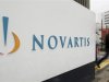 A man walks past the logo of Swiss drugmaker Novartis AG in front of a plant in Basel