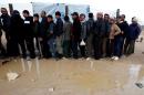 Syrian refugees wait to receive aid at the Al Zaatri Syrian refugee camp in Mafraq