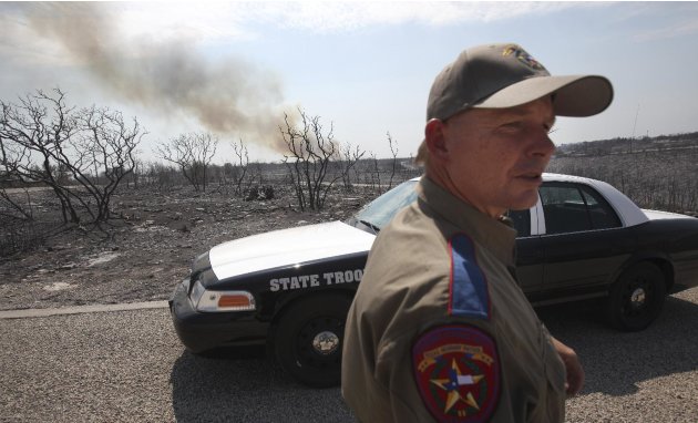 Texas State Trooper Garry Allen stands guard in an area destroyed by a wildfire at Possum Kingdom Lake, Texas, Wednesday, Aug. 31, 2011. (AP Photo/LM Otero)