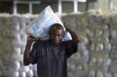 A worker carries packets of sugar at the Mumias sugar factory in western Kenya