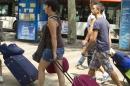 Varios jovenes turistas arrastran sus maletas camino a su hotel en las populares Ramblas de Barcelona. EFE/Archivo