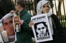 Demonstrators hold placards during a protest for Saudi blogger Raif Badawi, outside the Saudi Arabian Embassy in London