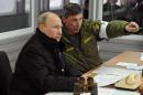 Russia's President Vladimir Putin (L) listens to the head of the Russian army's main department of combat preparation Ivan Buvaltsev (R) in the Leningrad region, on March 3, 2014