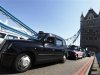 Taxi drivers in traditional black cabs drive slowly across Tower Bridge in protest at not being allowed to drive in the Olympic Lanes during the London 2012 Olympic Games