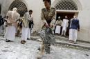 Houthi militant collects evidence at site of car bomb attack near Ismaili mosque in Yemen's capital Sanaa
