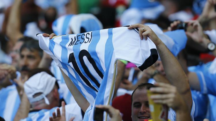 Fans of Argentina celebrate holding a jersey of Messi during their 2014 World Cup Group F soccer match against Iran at the Mineirao stadium in Belo Horizonte