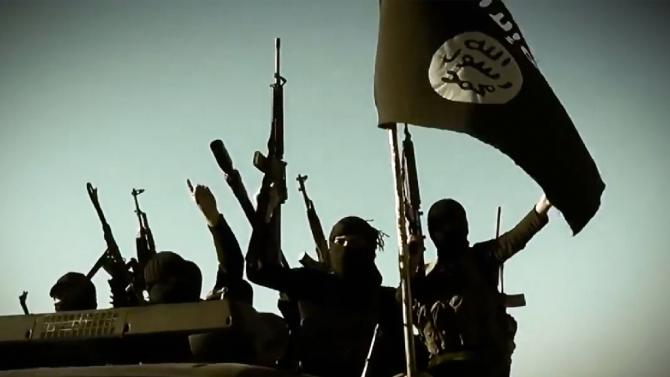 An image grab taken from a video released on March 17, 2014 by the Islamic State of Iraq and the Levant's al-Furqan Media allegedly shows ISIL fighters raising their weapons with the Jihadist flag at an undisclosed location
