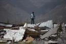 A man stands on top of a collapsed warehouse, looking for building material to salvage after Hurricane Odile destroyed his home in San Jose de los Cabos, Mexico, Thursday, Sept. 18, 2014. Water and electricity service remained out and phone service was intermittent. Odile struck late Sunday as a Category 3 storm. (AP Photo/Dario Lopez-Mills)