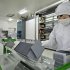 A masked worker sorts silicon wafers at the manufacturing centre of solar cell maker Trina Solar