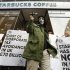 A masked demonstrator leaves a Starbucks coffee shop in central London
